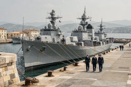 Vue grand angle de la base navale de Toulon avec des navires de guerre amarrés et des marins en uniforme sur le quai historique